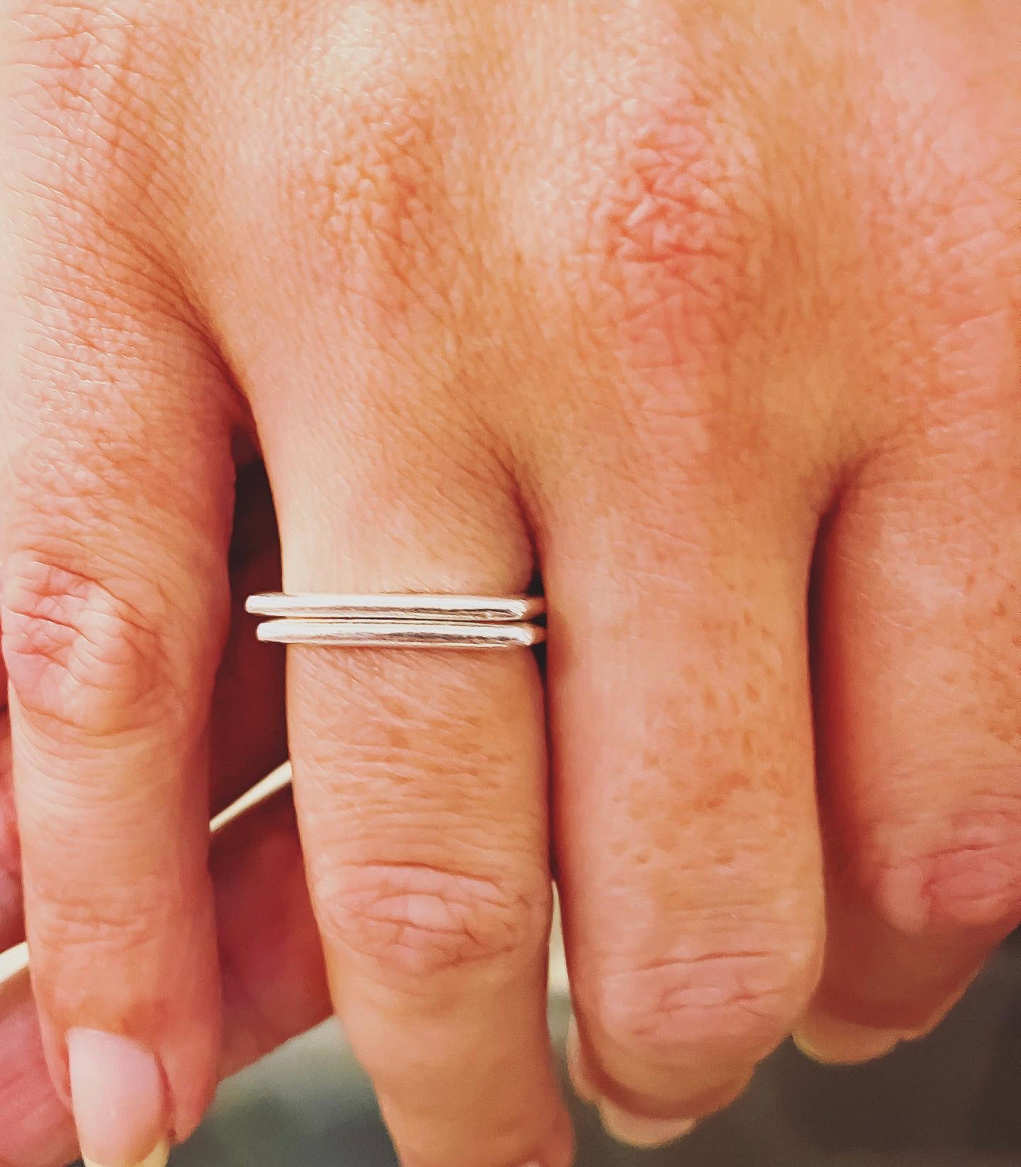 womens hand up close showing a square sterling silver stacking ring