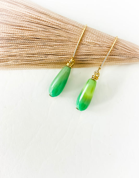 Seafoam Green Chyrophase oval shaped gold fill earrings against dried wheat grass